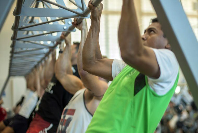 Athlete performing chin up test on overhead bar