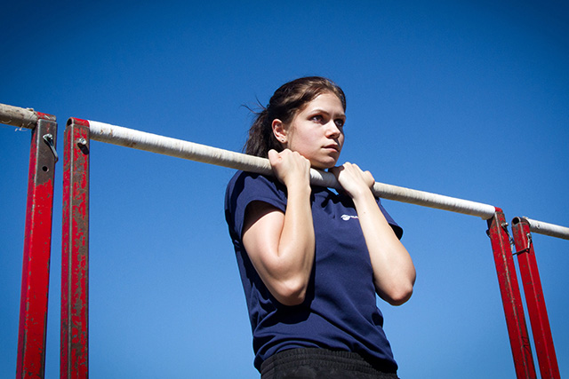 Athlete performing the flexed arm hang test on a pull-up bar
