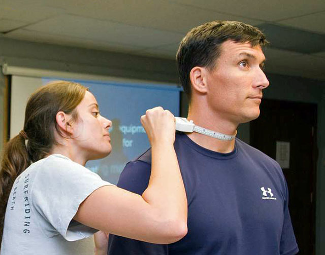 Neck girth testing procedure showing proper tape placement above Adam's Apple