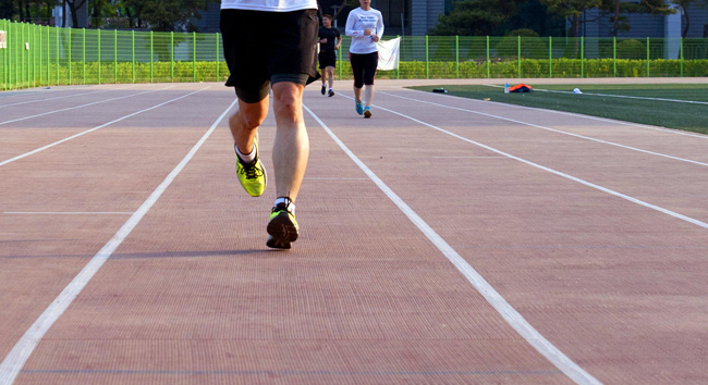 athletes jogging around a track during 1 mile run test